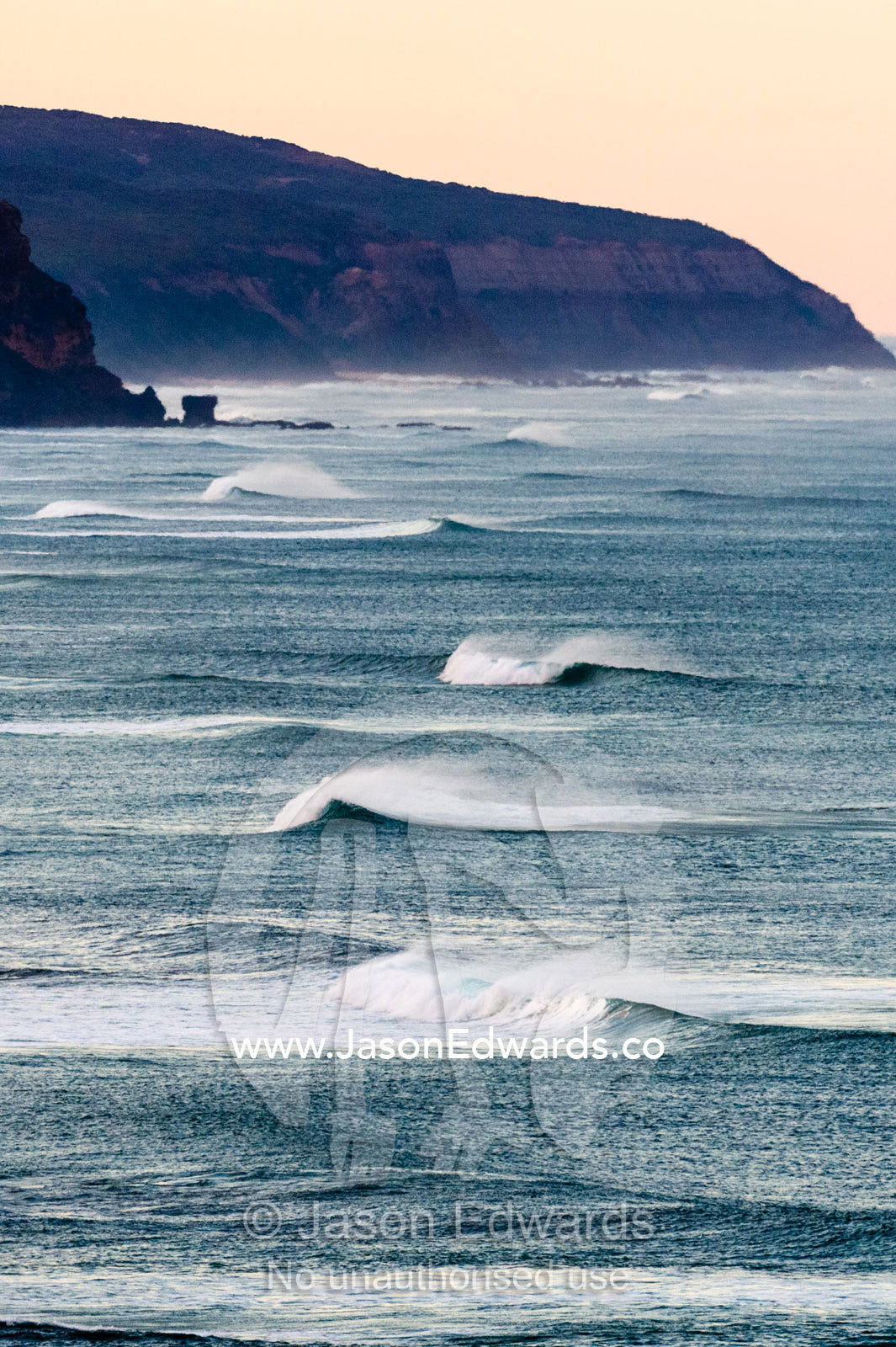 A line of perfect surfing waves crashing along a spectacular coast. Twelve Apostles, Port Campbell National, Great Ocean Road, Victoria, Australia.