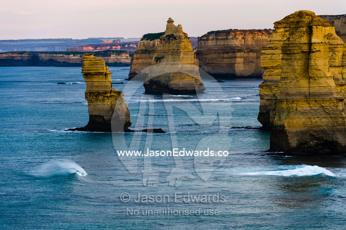 Waves breaking at the base of the Twelve Apostles limestone pillars. Twelve Apostles, Port Campbell National, Great Ocean Road, Victoria, Australia.