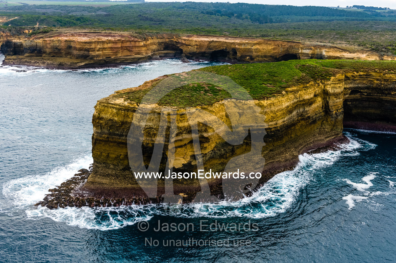 An aerial view of the ocean and the erosion on the sheer limestone cliffs and bays. Twelve Apostles, Port Campbell National, Great Ocean Road, Victoria, Australia.