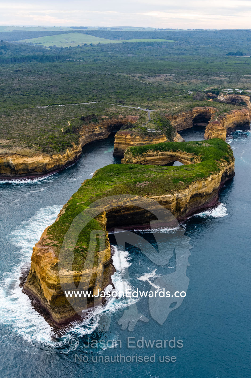 An aerial view of the ocean and the erosion on the sheer limestone cliffs and bays. Twelve Apostles, Port Campbell National, Great Ocean Road, Victoria, Australia.