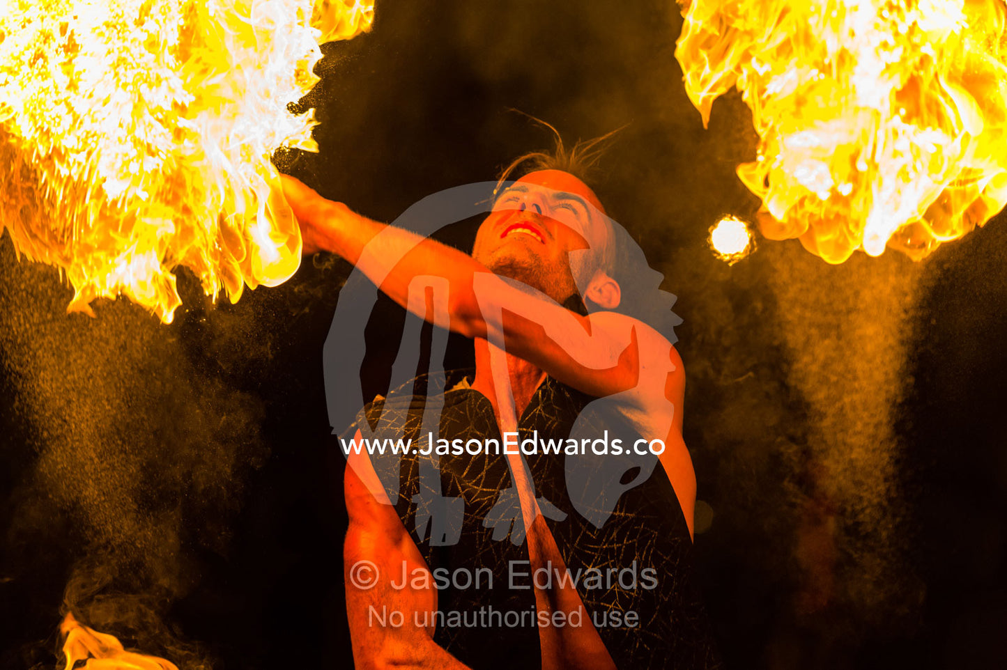A fire performer dazzles the crowd at an open-air market by throwing a flaming baton. Mindil Beach Sunset Markets, Darwin, Northern Territory, Australia.