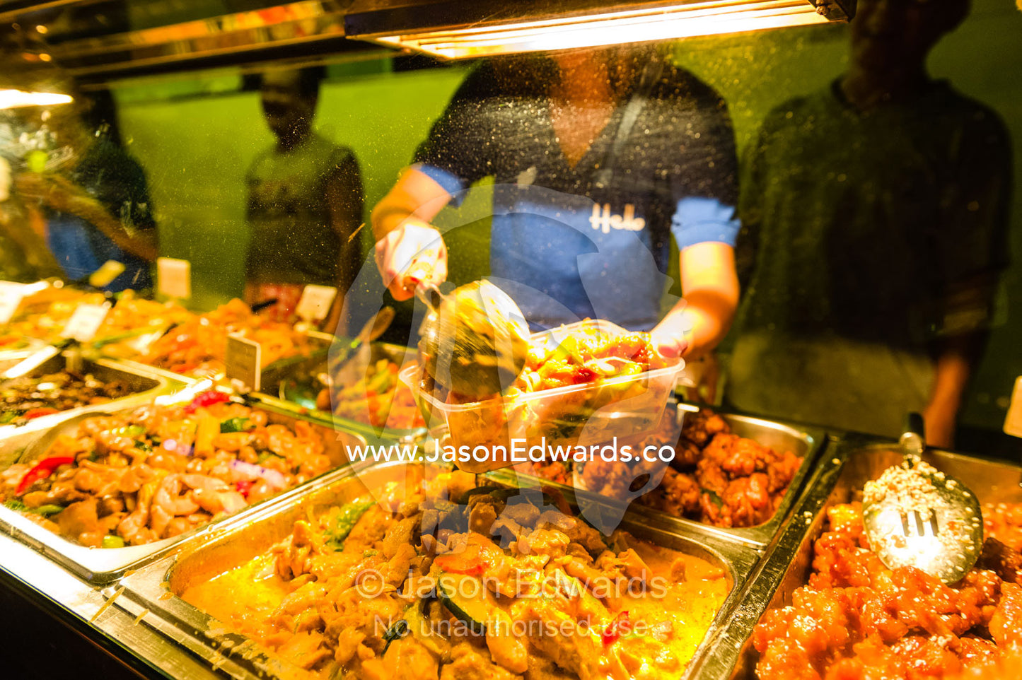 A chef prepares food in a take-away container at an open-air market. Mindil Beach Sunset Markets, Darwin, Northern Territory, Australia.