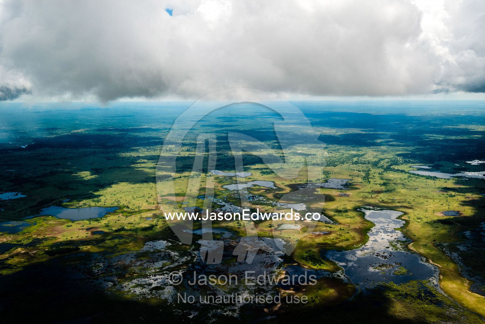 A storm gathers over the rivers, streams and waterholes of a floodplain. Okavango Delta, Botswana.