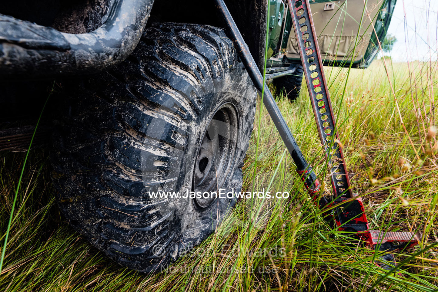 Using a high lift jack to change a flat tire on a 4wd. Duba Plains Camp, Ngamiland West, Botswana.