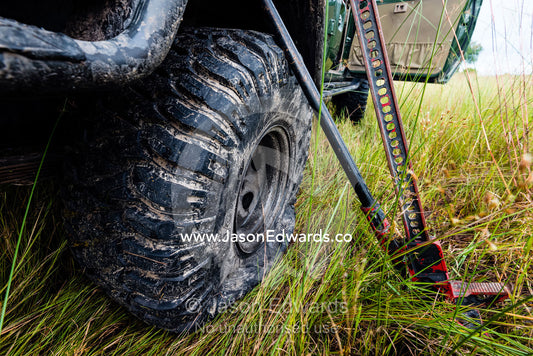 Using a high lift jack to change a flat tire on a 4wd. Duba Plains Camp, Ngamiland West, Botswana.
