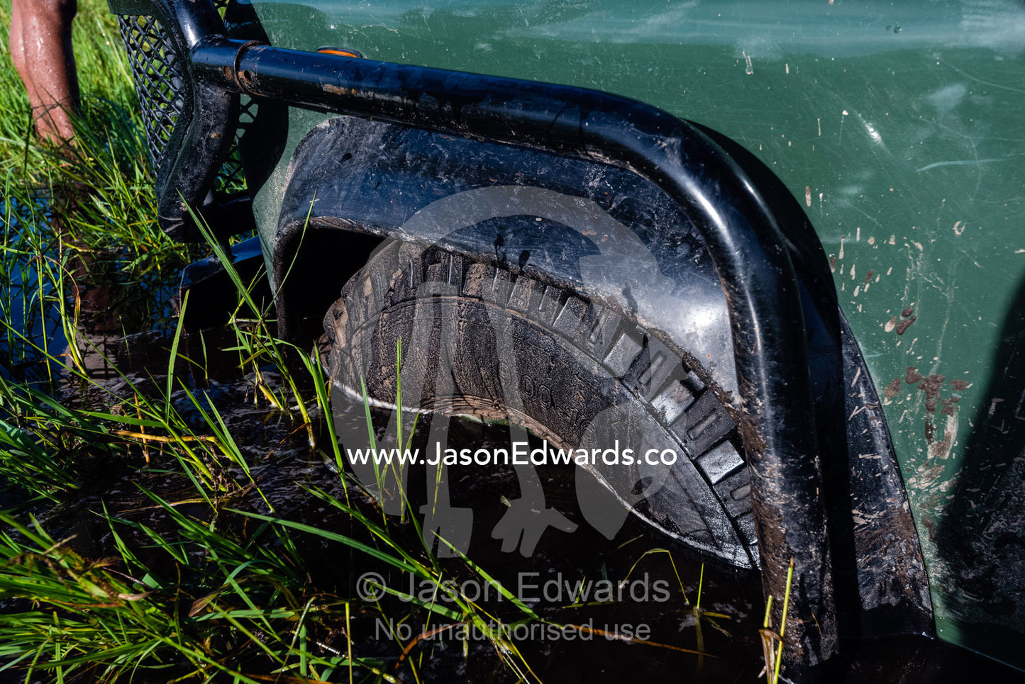 The front wheel of a 4wd bogged in the water and mud of a floodplain. Duba Plains Camp, Ngamiland West, Botswana.