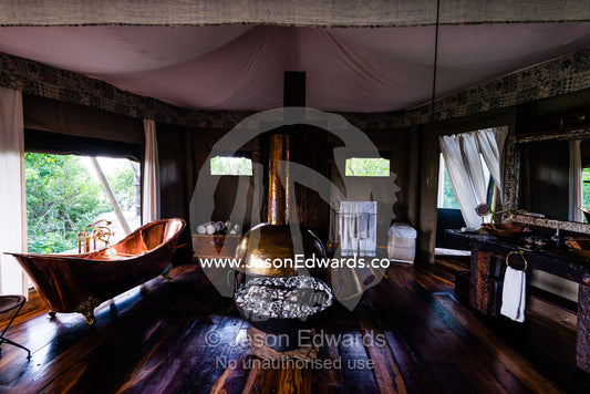 A brass fire place and brass bath in a luxurious safari camp tent. Zarafa Camp, Zibadianja Lagoon, Savute Channel, Linyanti, Botswana.