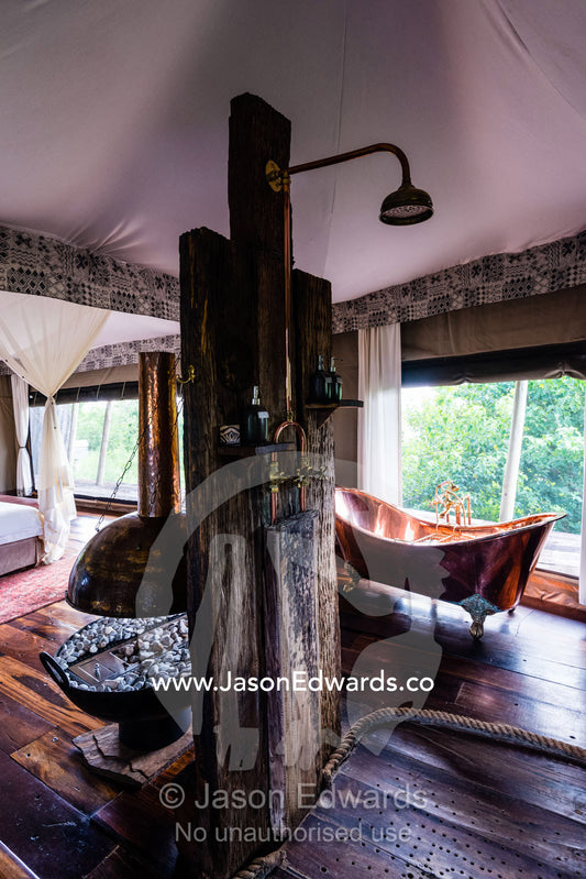 A brass fire place and brass bath in a luxurious safari camp tent. Zarafa Camp, Zibadianja Lagoon, Savute Channel, Linyanti, Botswana.