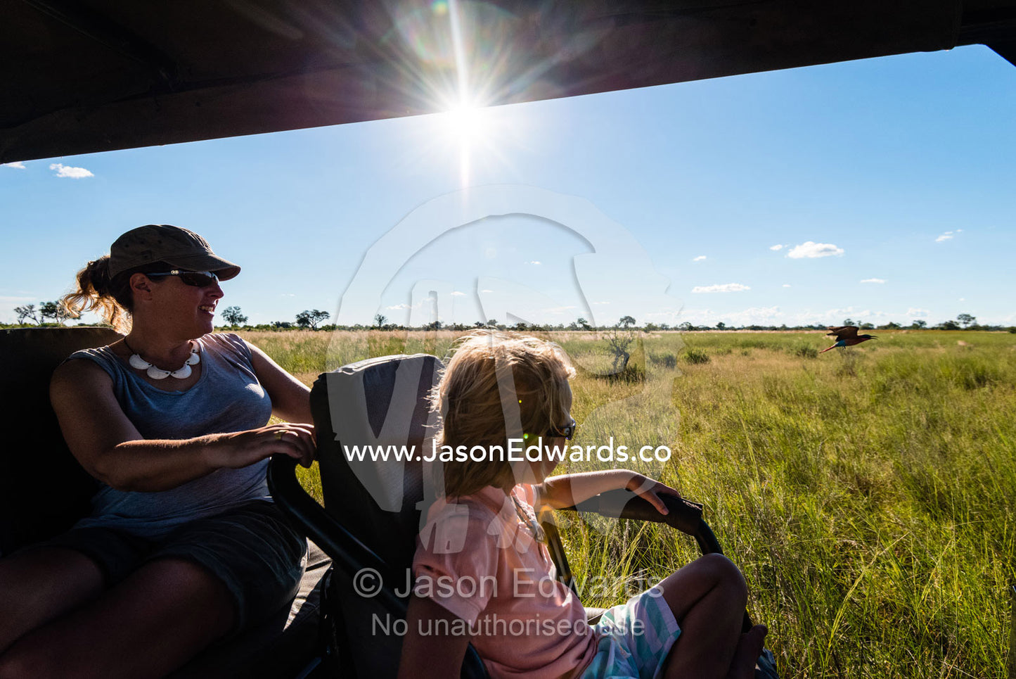 A mother and son in a safari 4wd searching for wildlife. Selinda Reserve, Linyanti Region, Northern Botswana.