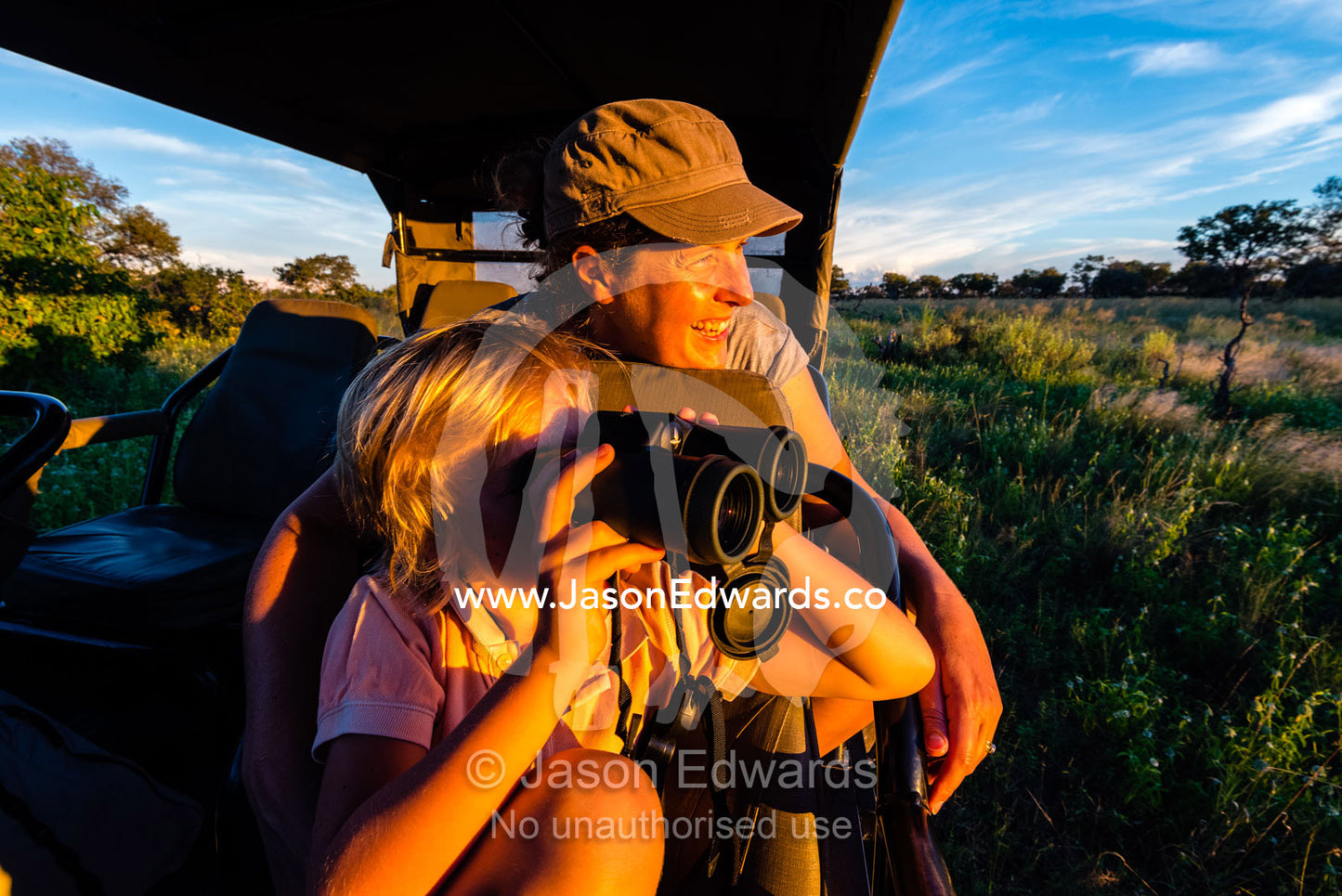 A mother and son in a safari 4wd watching wildlife. Selinda Reserve, Linyanti Region, Northern Botswana.