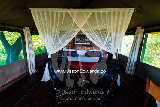 A mosquito net around a bed in a luxurious safari camp tent. Selinda Camp, Selinda Reserve, Linyanti Region, Northern Botswana.
