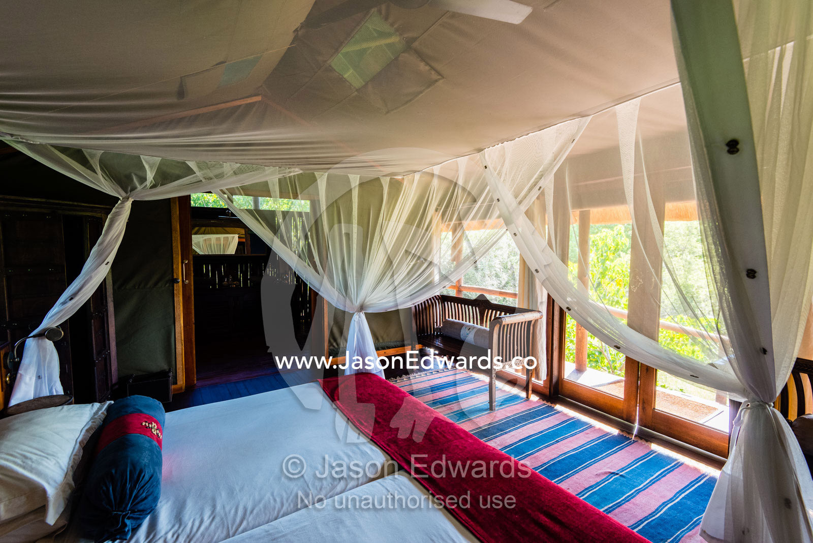 A mosquito net around a bed in a luxurious safari camp tent. Selinda Camp, Selinda Reserve, Linyanti Region, Northern Botswana.