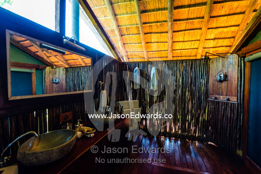 A wash basin and mirror in a luxurious safari camp tent. Selinda Camp, Selinda Reserve, Linyanti Region, Northern Botswana.
