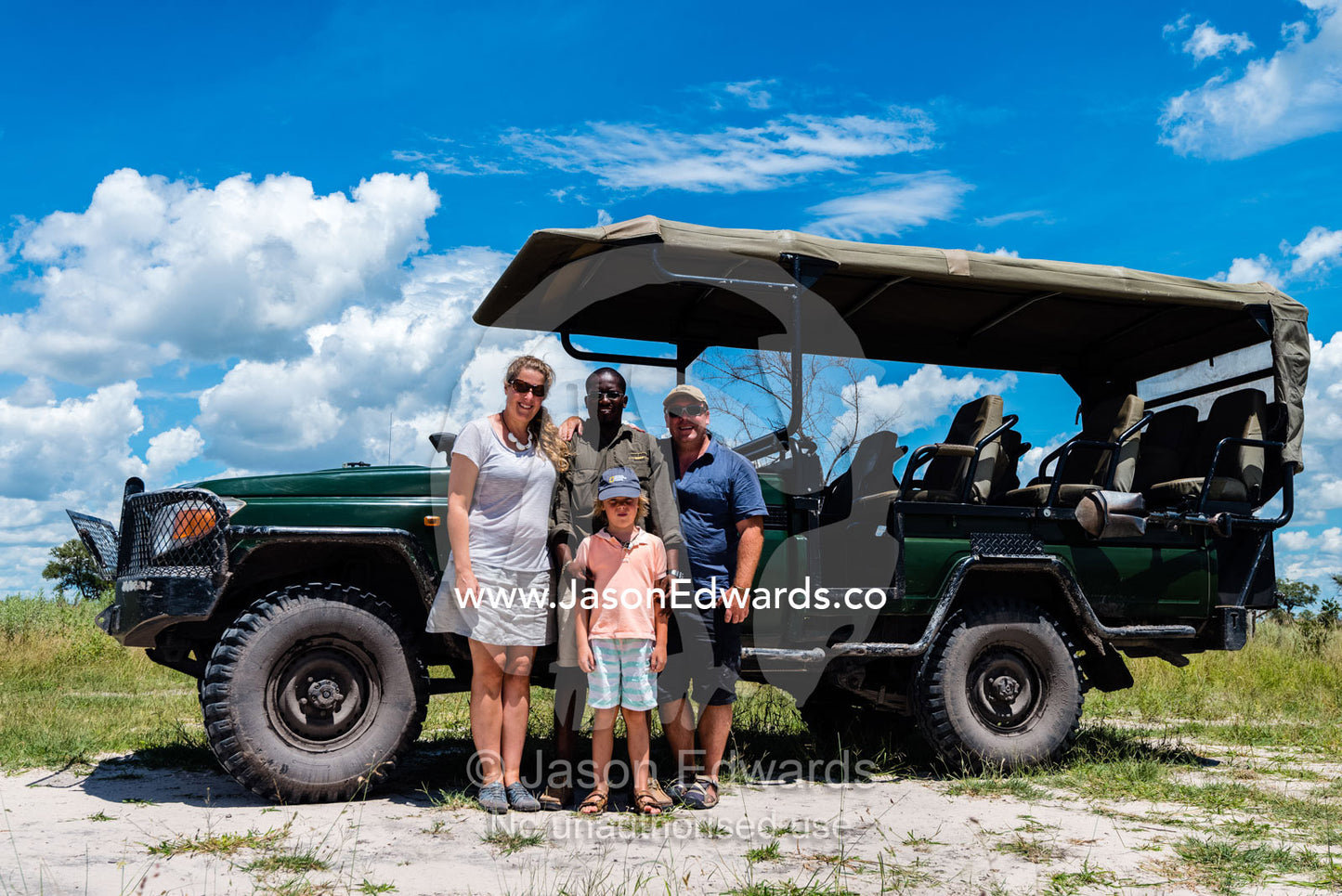 A family with their safari guide and 4wd. Selinda Reserve, Linyanti Region, Northern Botswana.