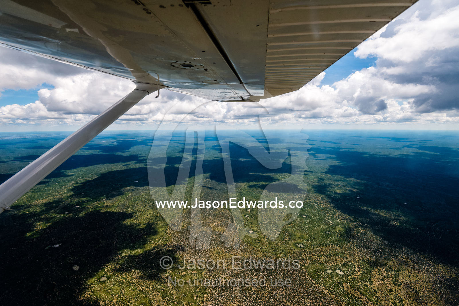 An aerial view of an African savannah from beneath the wing of a light plane. Okavango Delta, Botswana.