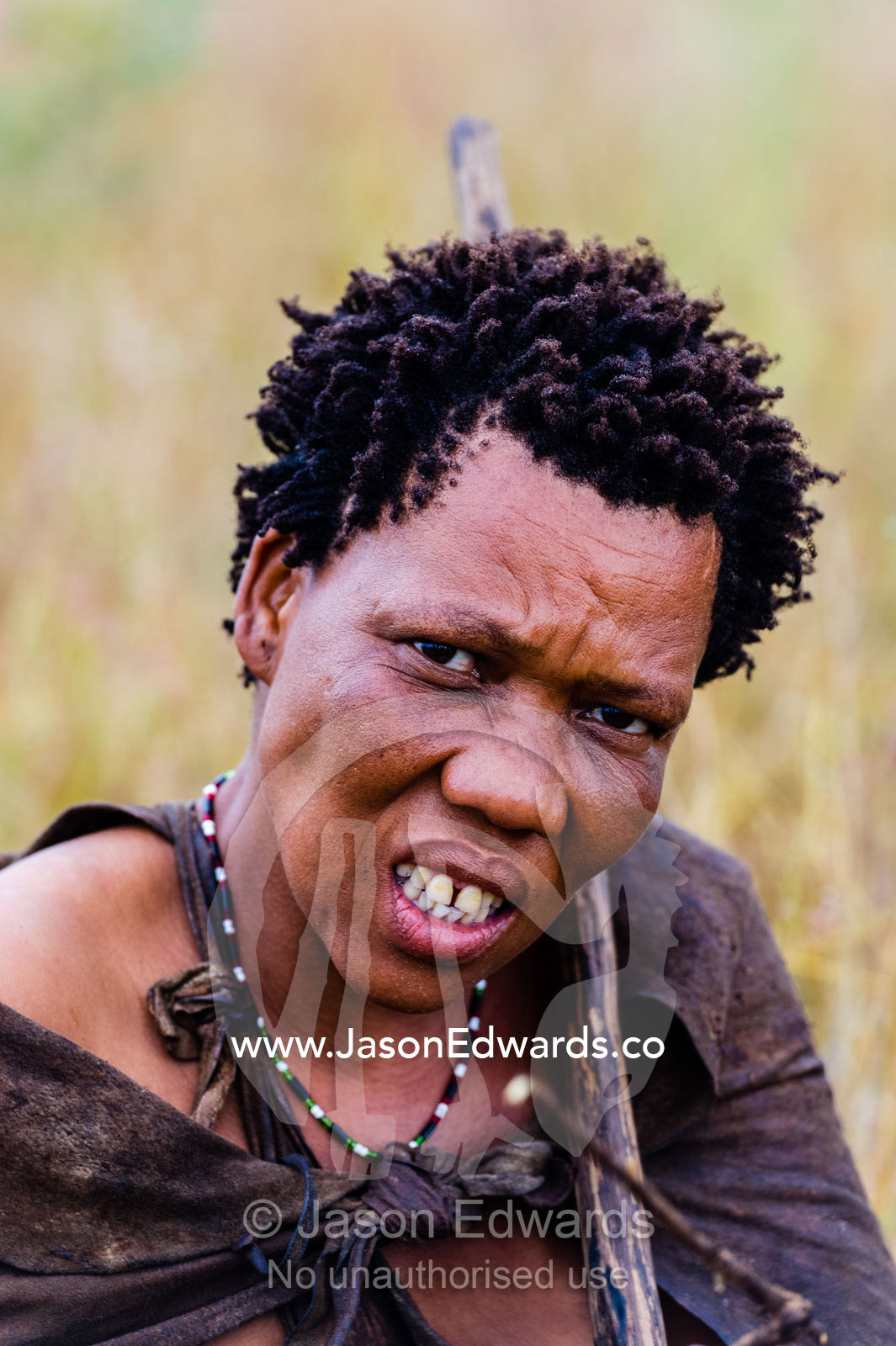 A portrait of a San Bushmen woman wearing leather animal skins. Kalahari Desert, Botswana.