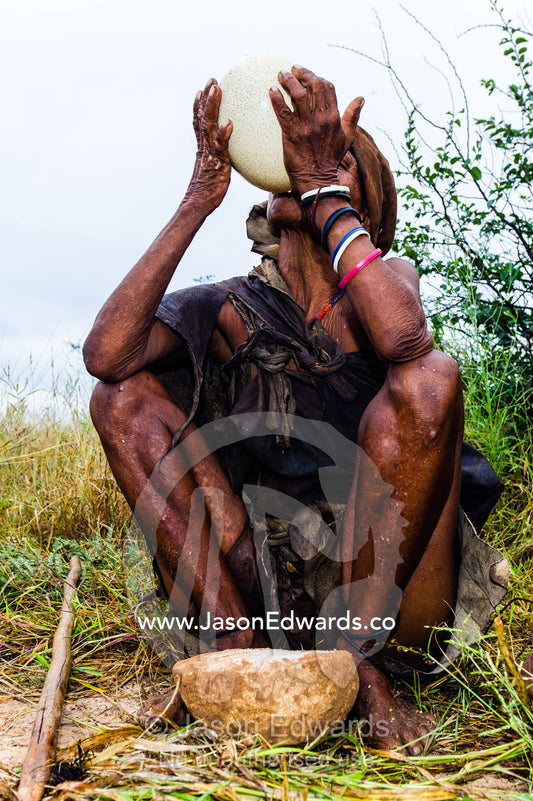 A San Bushmen woman drinking water from an Ostrich egg. Kalahari Desert, Botswana.