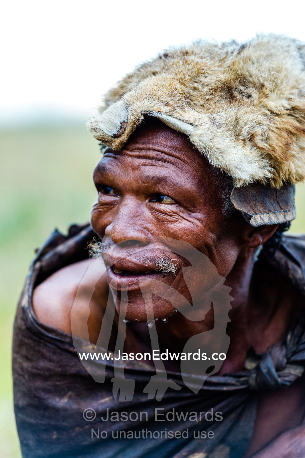 A San Bushmen man wearing the fur of a jackal as a hat. Kalahari Desert, Botswana.