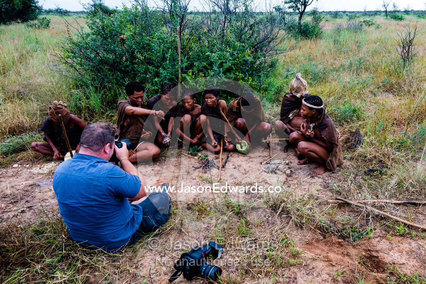A photographer captures San Bushmen preparing breakfast in the desert. Kalahari Desert, Botswana.