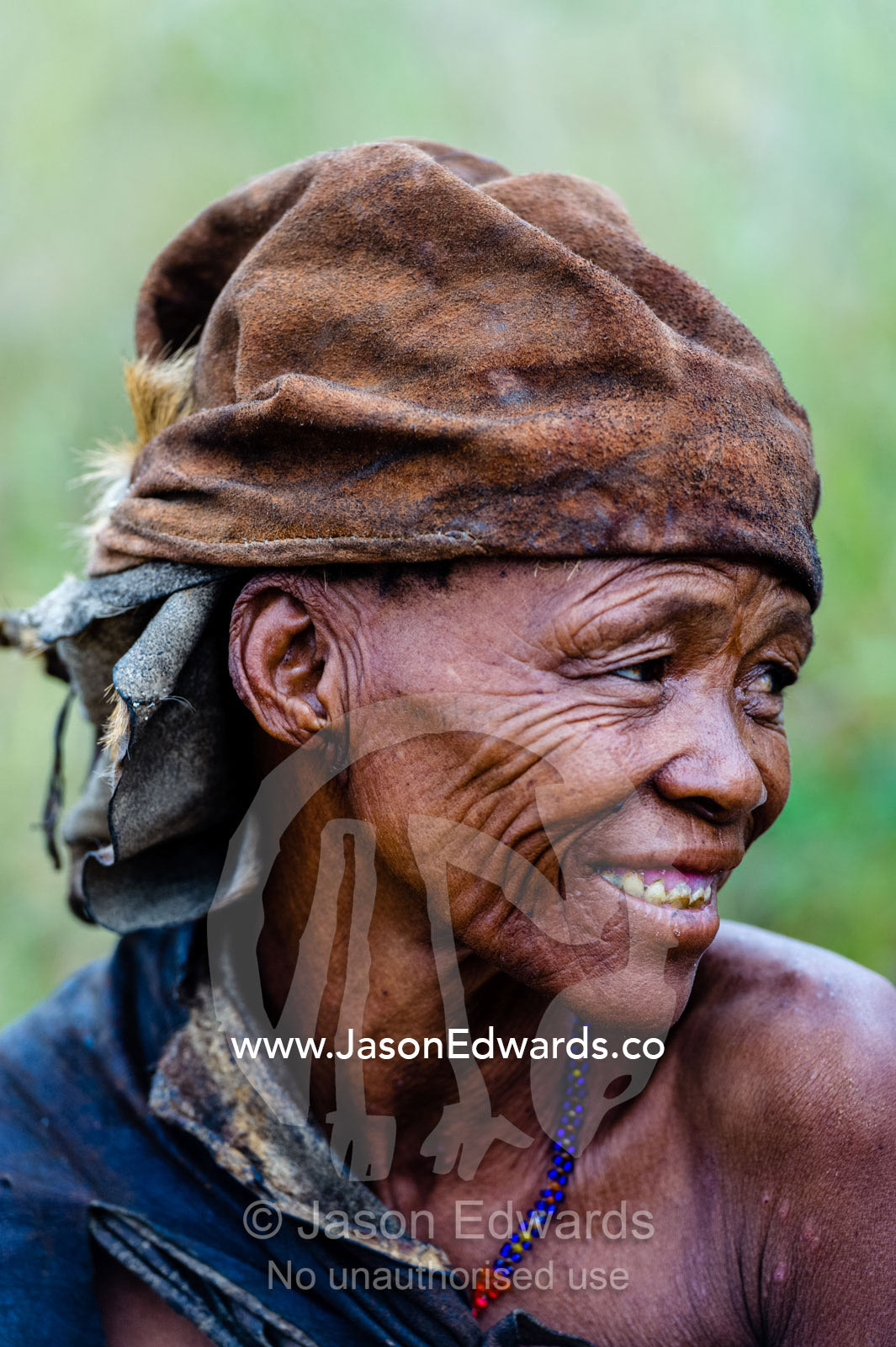 A San Bushmen woman wearing a leather animal skin hat. Kalahari Desert, Botswana.