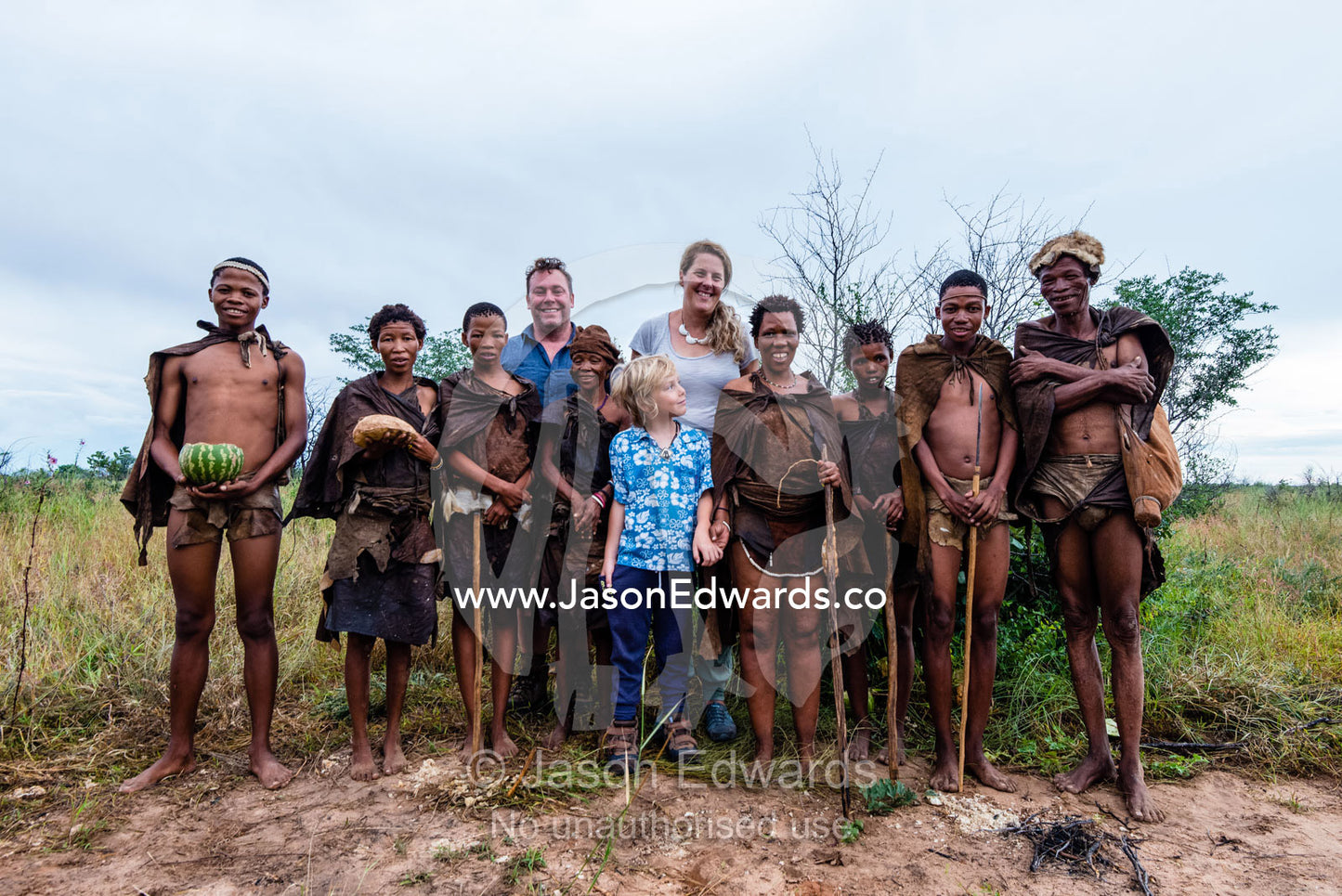 A western family with a San Bushmen family in the Kalahari. Kalahari Desert, Botswana.