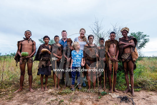 A western family with a San Bushmen family in the Kalahari. Kalahari Desert, Botswana.