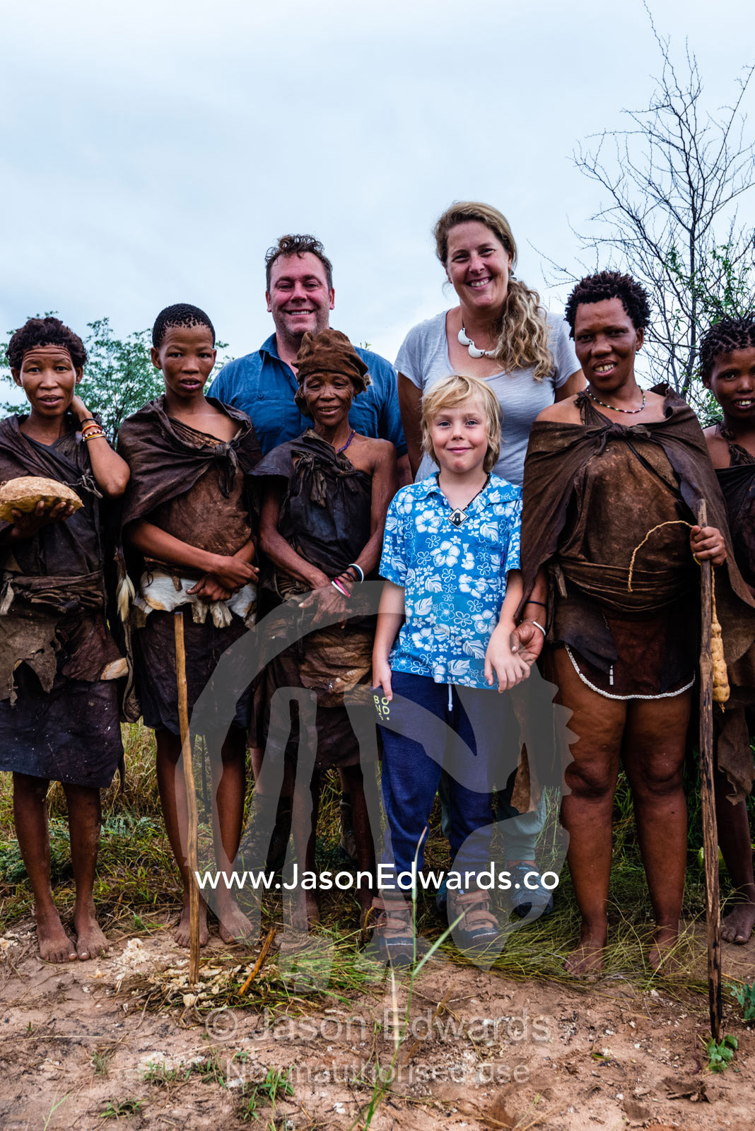 A western family with a San Bushmen family in the Kalahari. Kalahari Desert, Botswana.