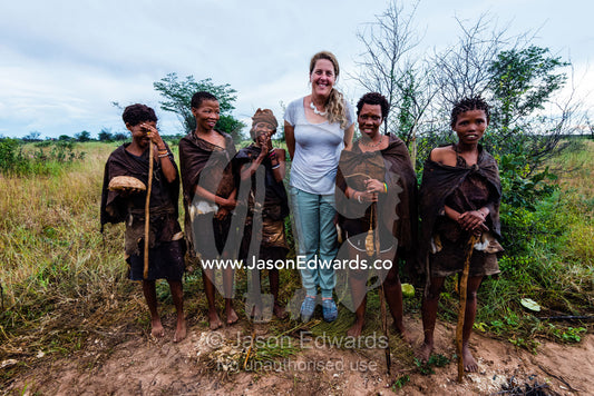 A western woman with the women of a San Bushmen family in the Kalahari. Kalahari Desert, Botswana.