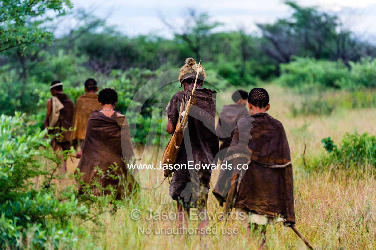 A family of San Bushmen walking through the Kalahari Desert. Kalahari Desert, Botswana.