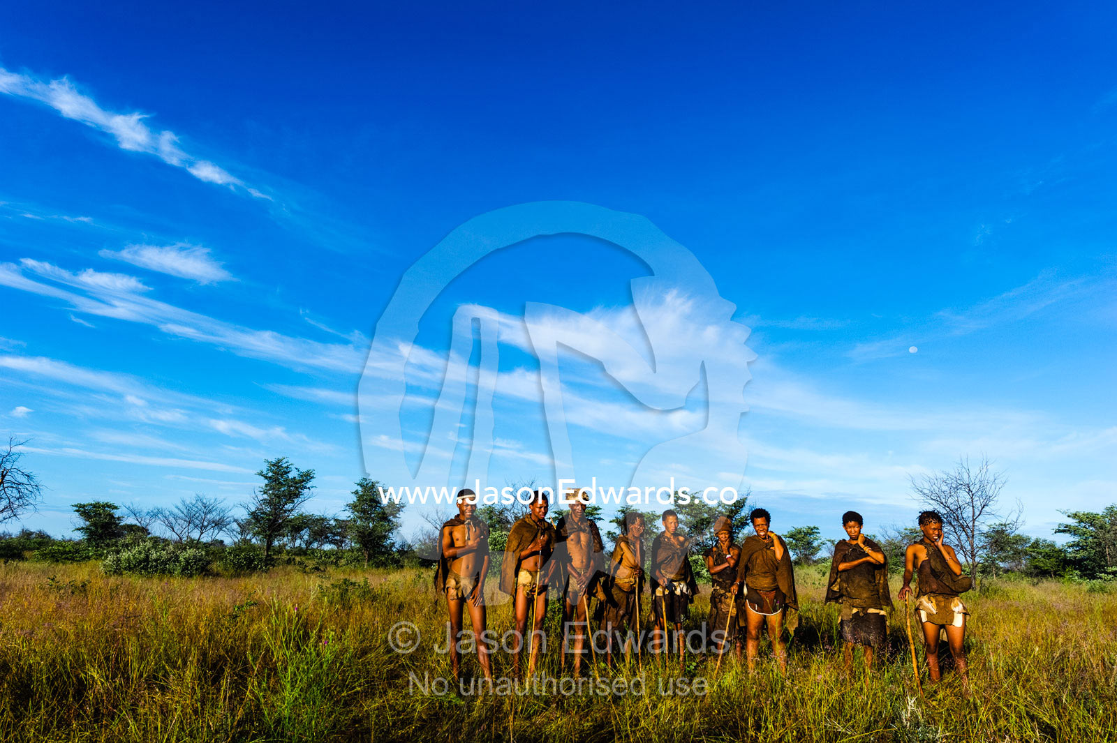 Generations of a San Bushmen family on a grassland at dawn. Kalahari Desert, Botswana.