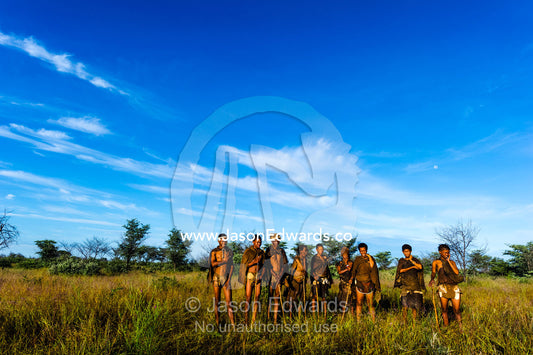 Generations of a San Bushmen family on a grassland at dawn. Kalahari Desert, Botswana.