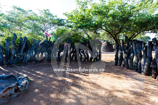 A log wildlife fence surrounds a hut for tourists to sleep in Botswana. Kalahari Desert, Botswana.