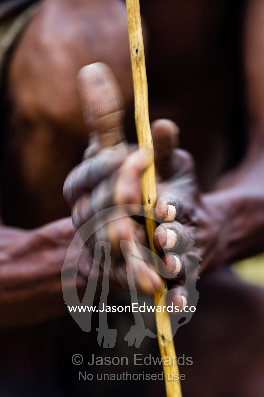 San Bushmen starting a fire using kindling, a wooden drill of hard wood and a soft wood fire board. Kalahari Desert, Botswana.
