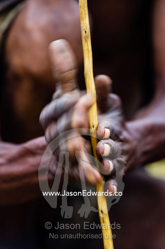 San Bushmen starting a fire using kindling, a wooden drill of hard wood and a soft wood fire board. Kalahari Desert, Botswana.