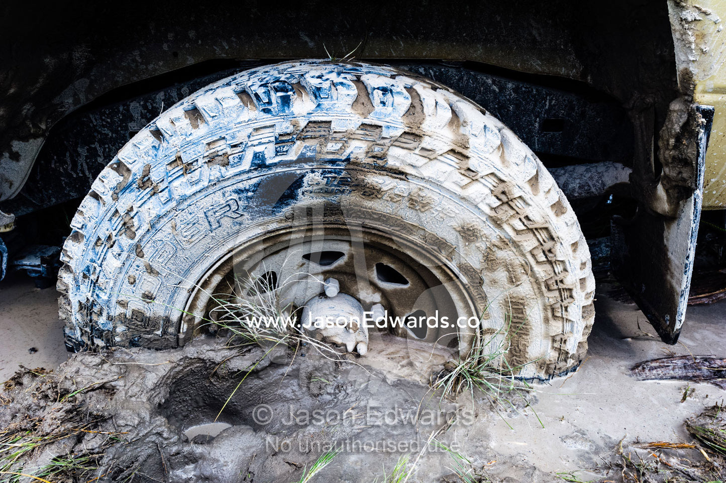The wheel of a 4wd safari vehicle trapped in mud. Makgadikgadi Pans, Botswana.