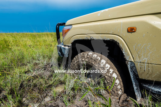 The wheel of a 4wd safari vehicle trapped in mud. Makgadikgadi Pans, Botswana.