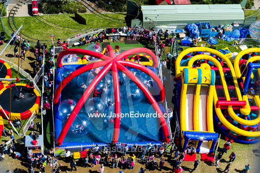 Inflatable swimming pool and slide and sideshow attractions at an agricultural show. Royal Melbourne Show, Flemington, Melbourne, Victoria, Australia.