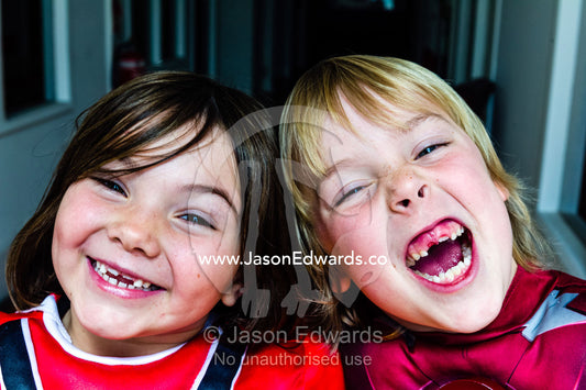 A boy and a girl laugh displaying the gaps in their front teeth. Collingwood, Melbourne, Victoria, Australia.