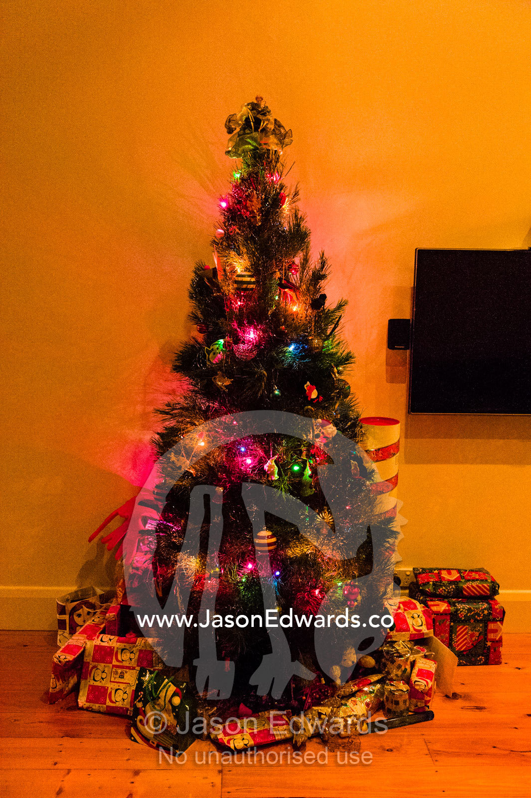 A Christmas tree decorated at night in a living room. Carlton North, Melbourne, Victoria, Australia.