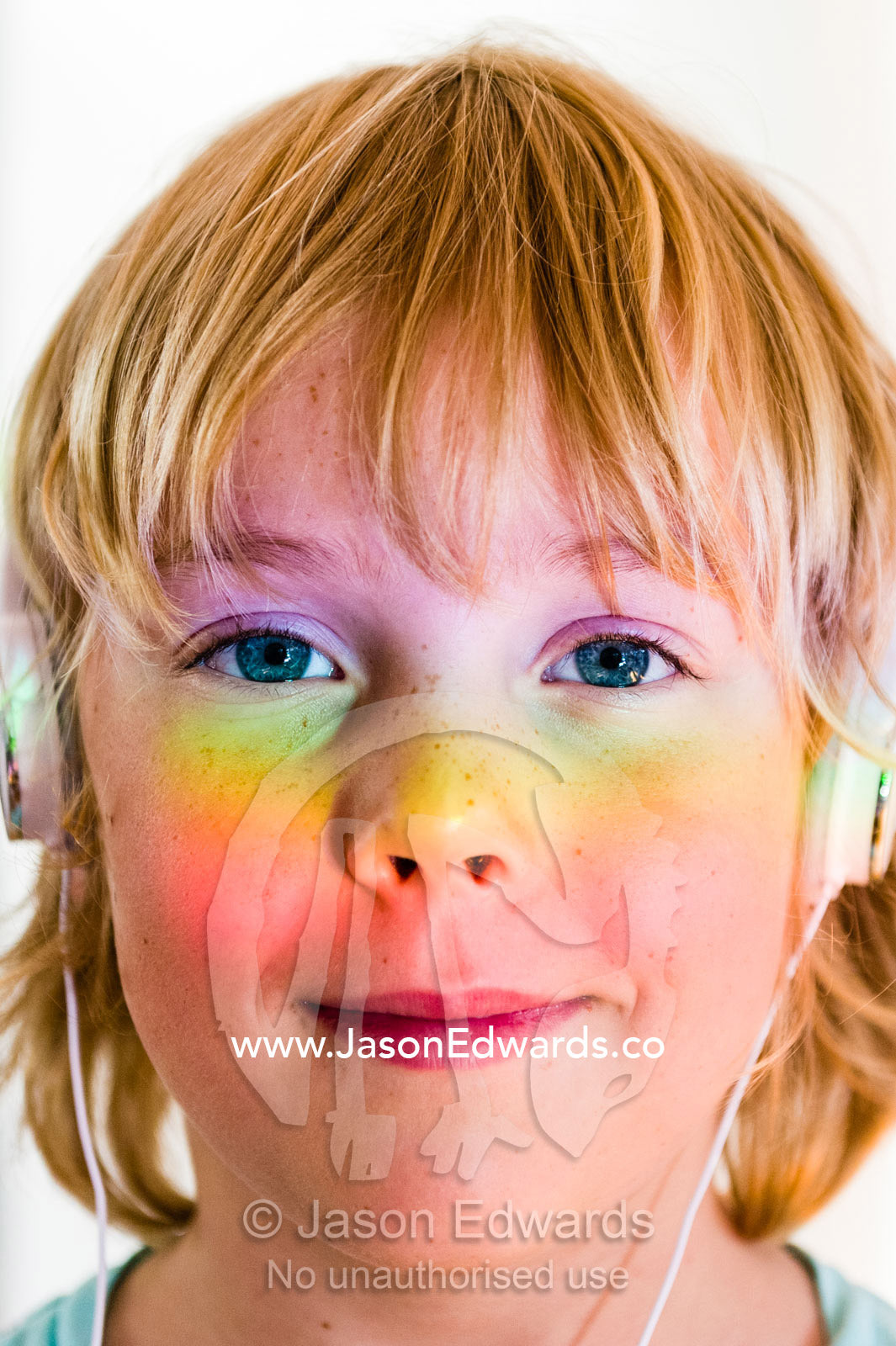 A boys face covered in a prism of rainbow colors through a window. Malvern East, Melbourne, Victoria, Australia.