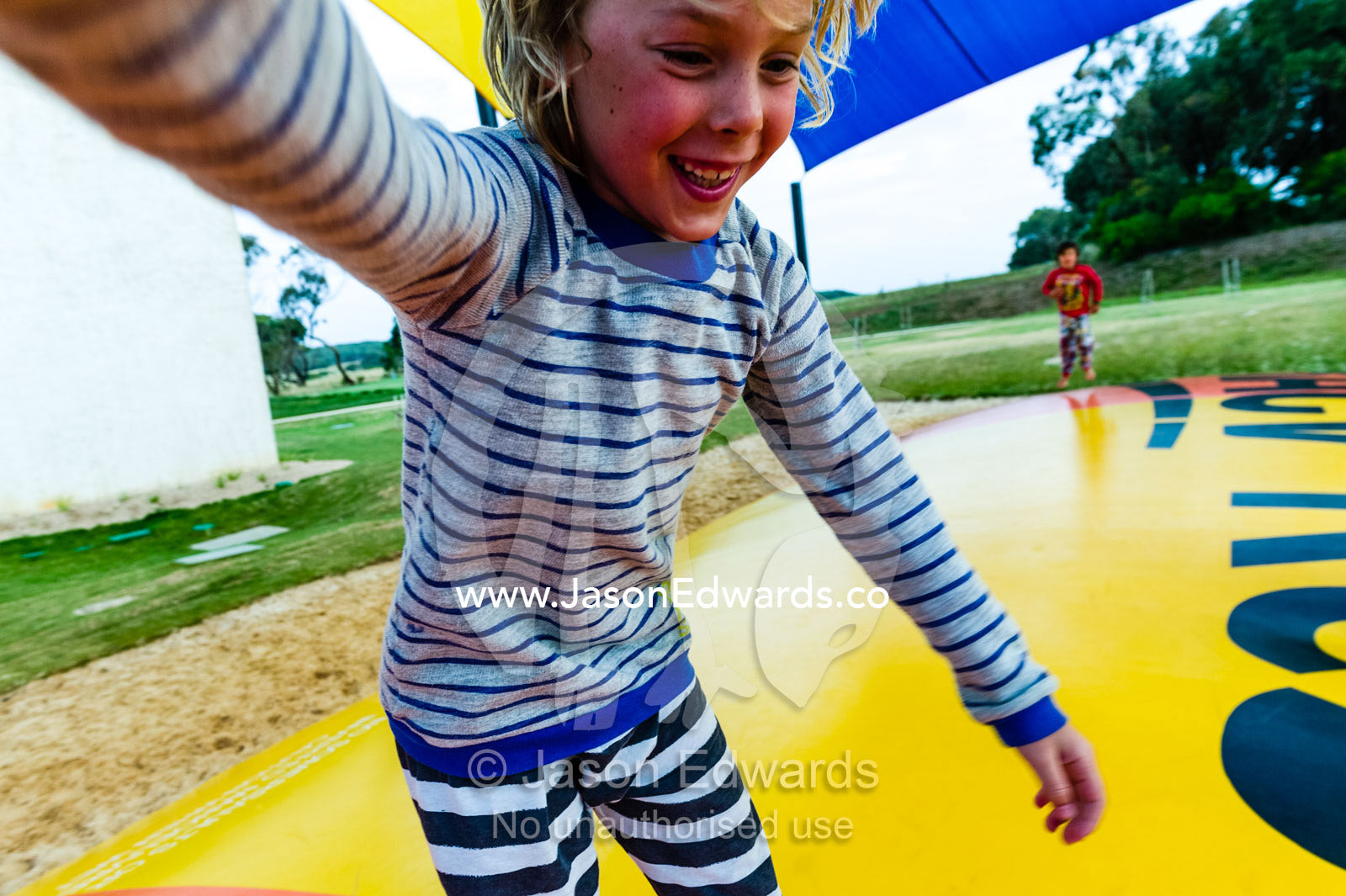 A boy bounces on an inflatable cushion at a hotel. Torquay, Surf Coast, Victoria, Australia.