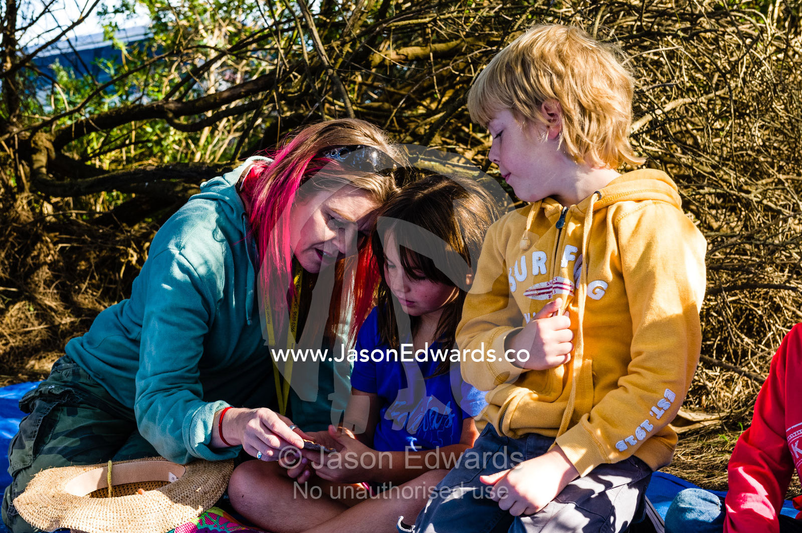 A teacher on a school excursion to the beach shows her students ocean specimens. Ricketts Point Marine Sanctuary, Port Phillip Bay, Victoria, Australia.