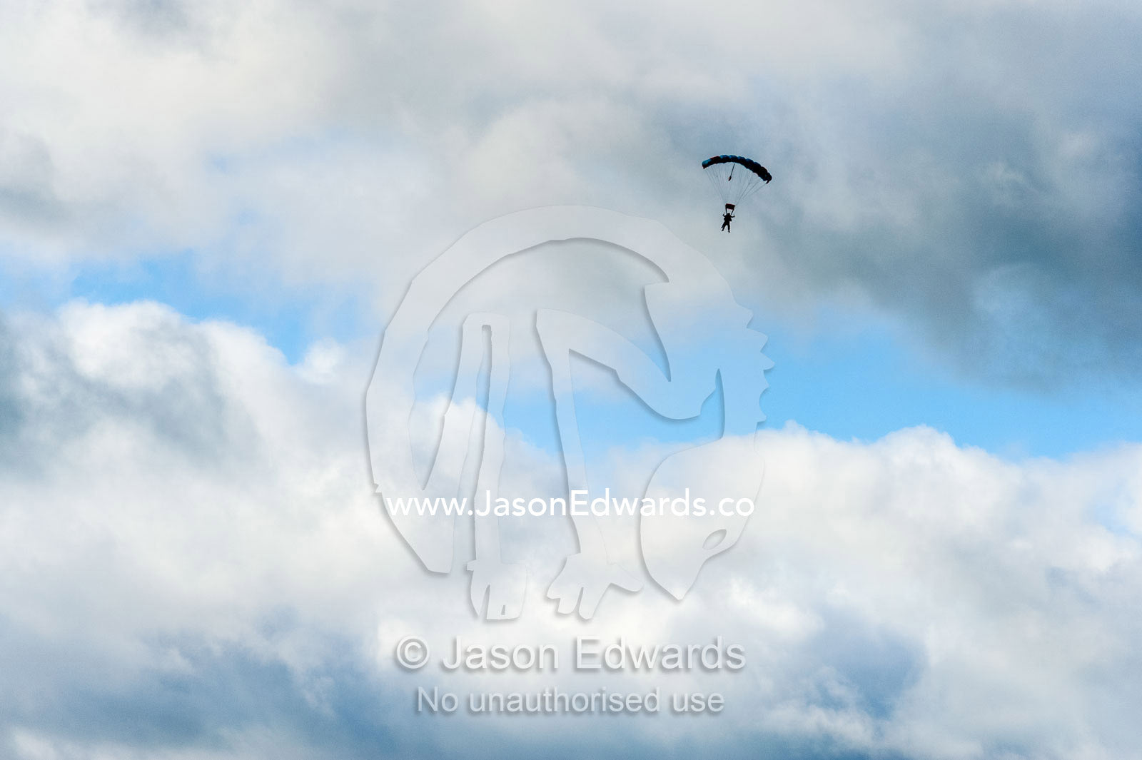 A parachute falls through a stormy sky. Torquay, Surf Coast, Victoria, Australia.
