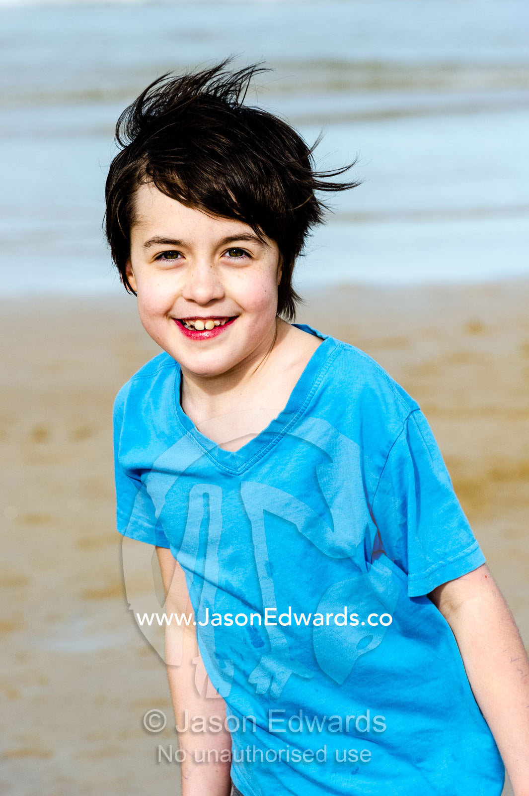 A smiling and happy girl playing on a beach. Torquay, Surf Coast, Victoria, Australia.