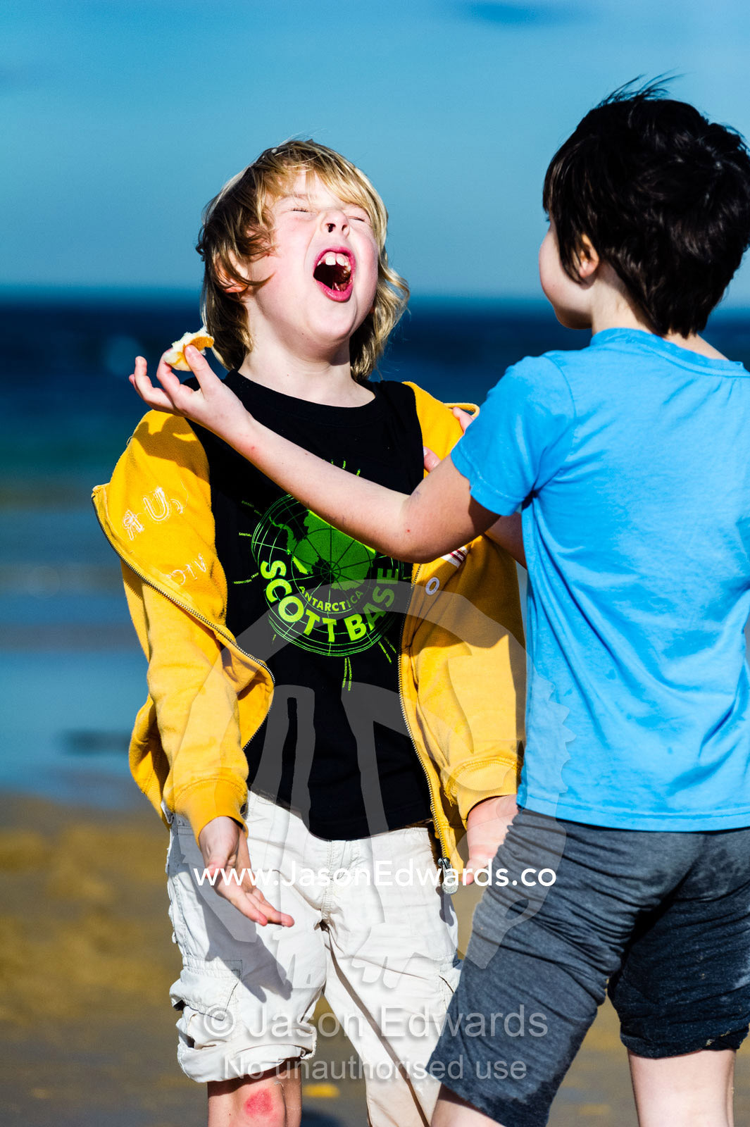 Young friends playing on a beach by the ocean. Torquay, Surf Coast, Victoria, Australia.