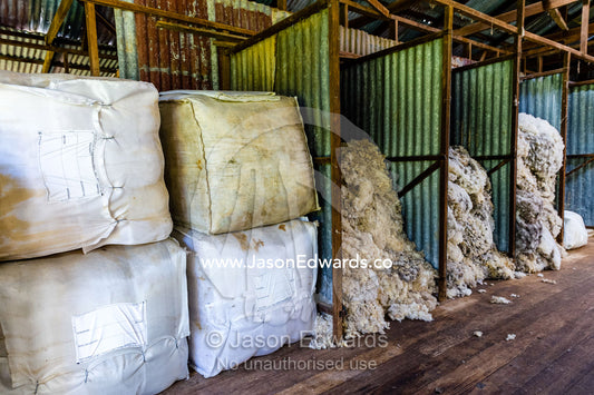 Bales of wool and sheep wool sorted into quality grades in a shearing shed. Euroa, Strathbogie, Victoria, Australia.