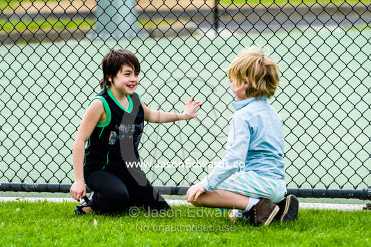 Friends talking on a sports during a school excursion. Albert Park, Melbourne, Victoria, Australia.