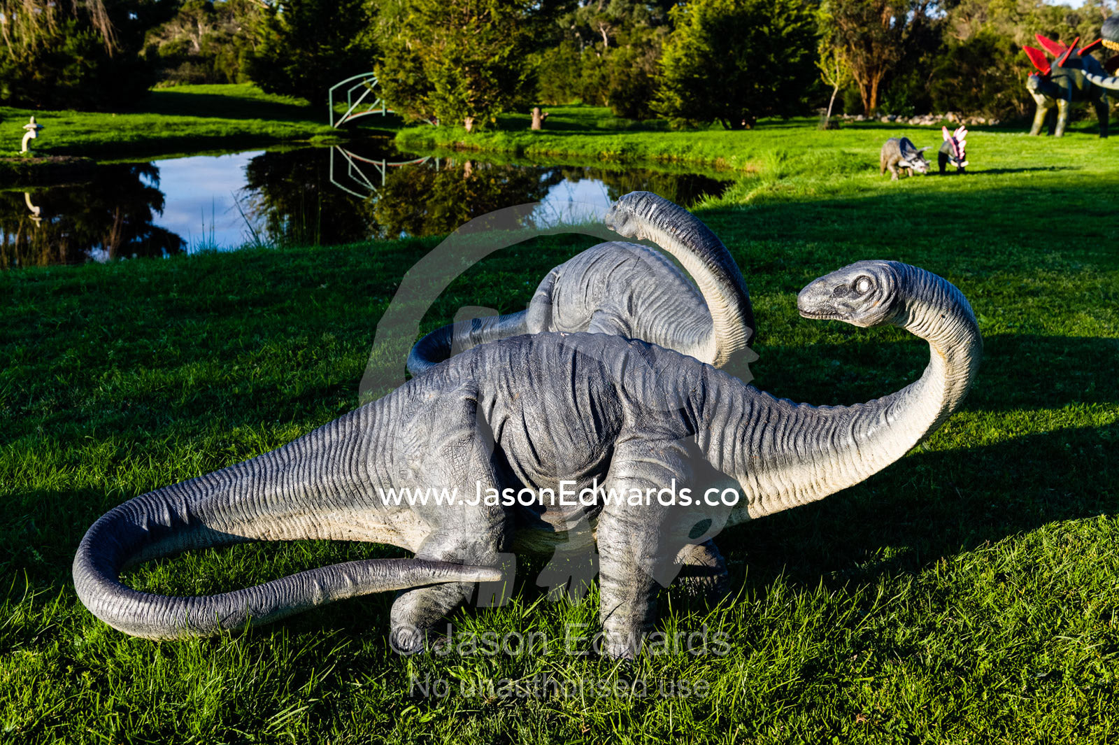 A pair of model Brachiosaurus dinosaurs in a garden. Devon Meadows, Melbourne, Victoria, Australia.
