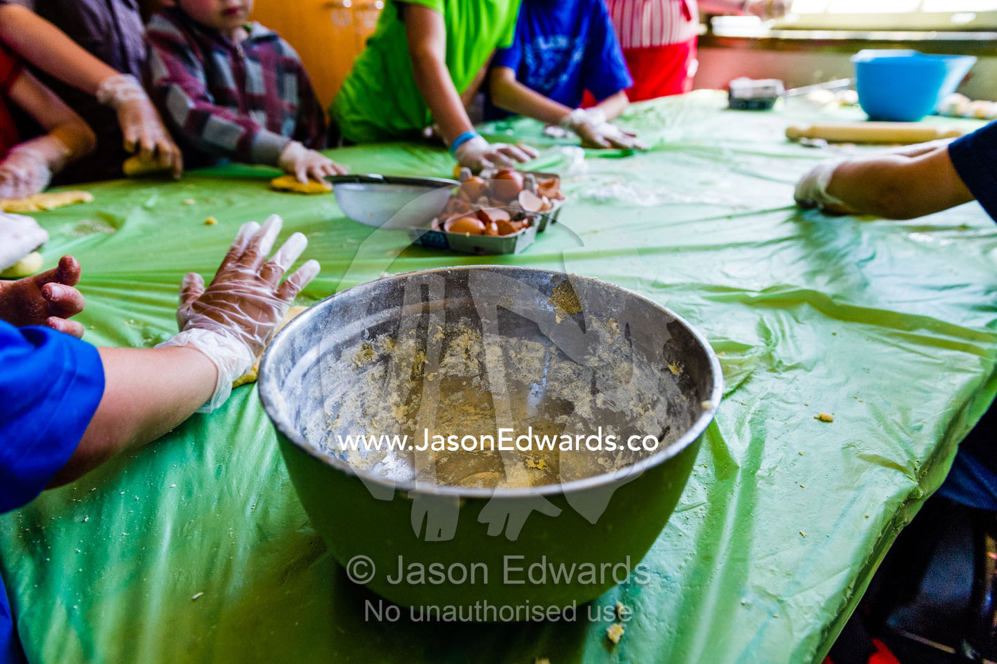 School children making pasta wearing food safe disposable gloves and a stainless steel bowl. Carlton North, Melbourne, Victoria, Australia.