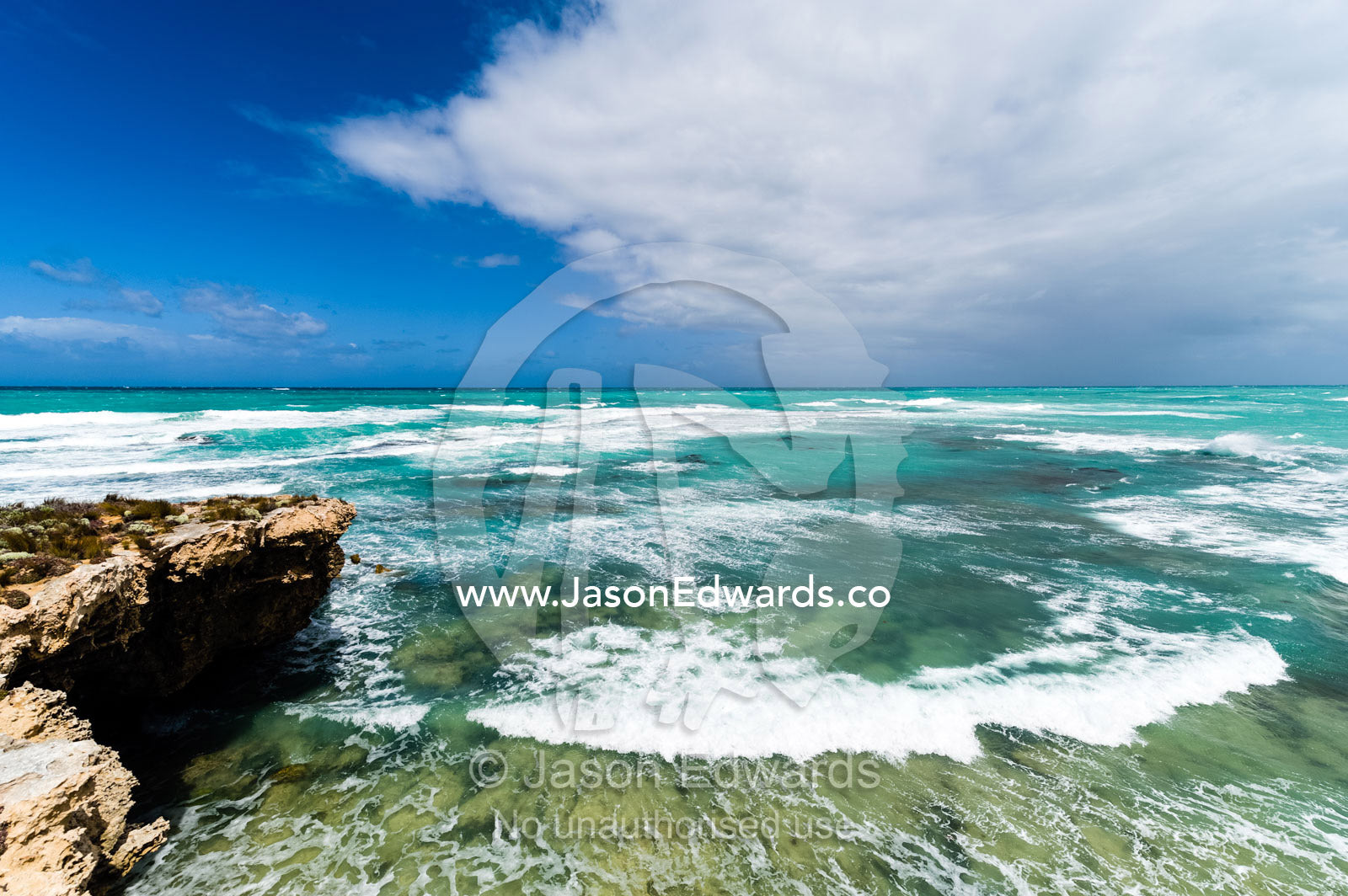 Strong winds whipping waves onto a rugged limestone coastline. Robe, Limestone Coast, South Australia, Australia.